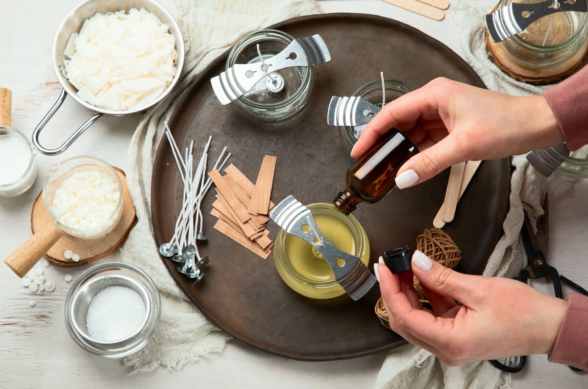 Woman making decorative aroma candle at table